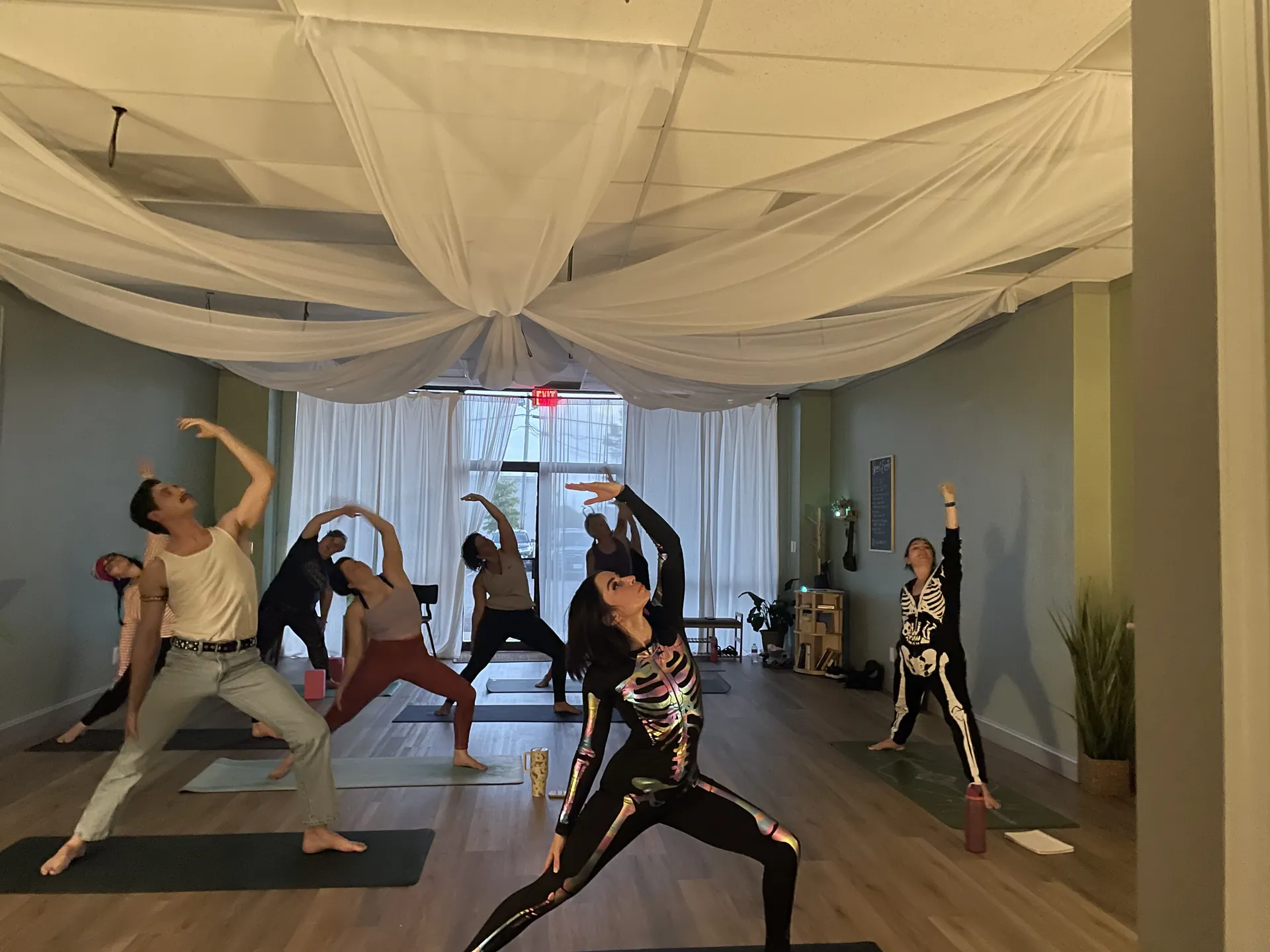 A class in warrior poses beneath the draped ceiling of the studio.