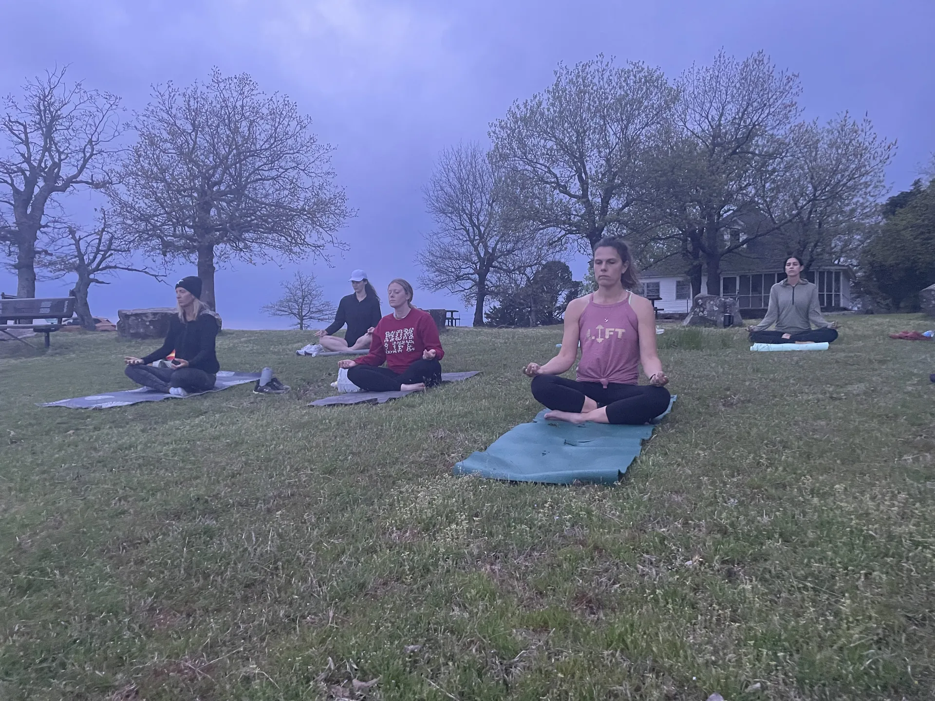 Early-morning meditation on Mount Nebo, students seated on their mats under grey skies.