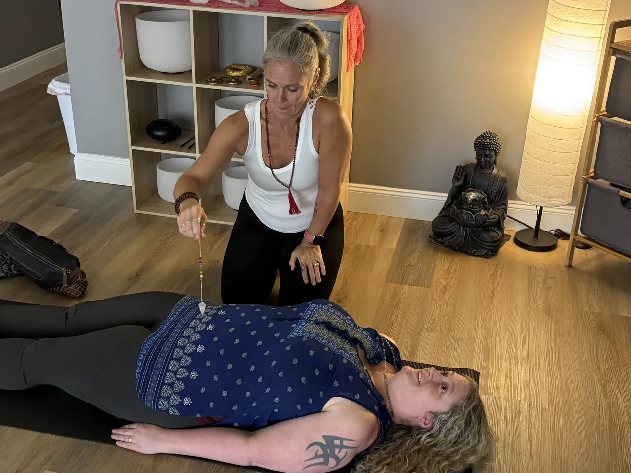 Jill working one on one with a client lying on a mat during an individual session.