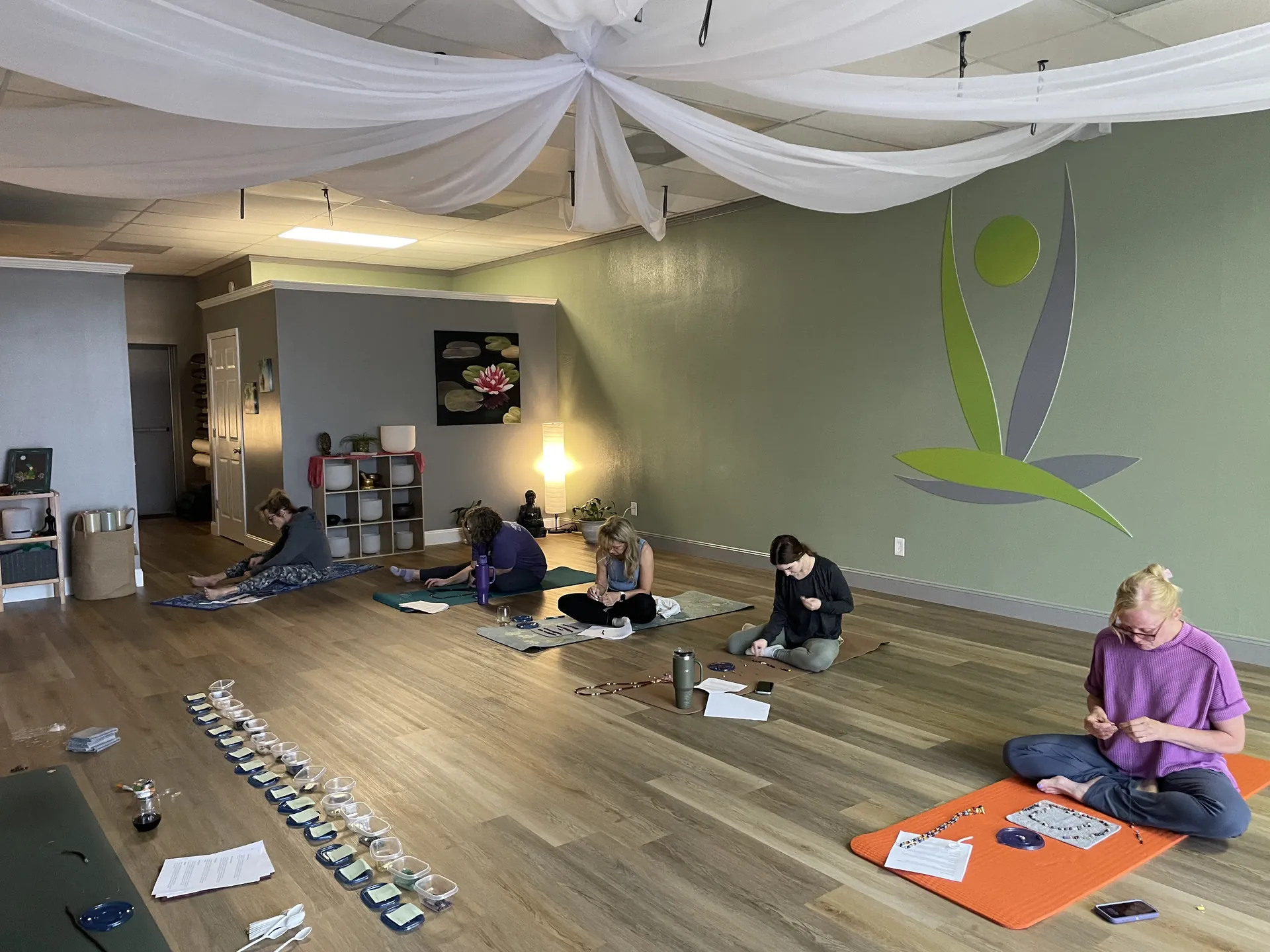 Students stringing mala beads across the studio floor during a mala workshop.