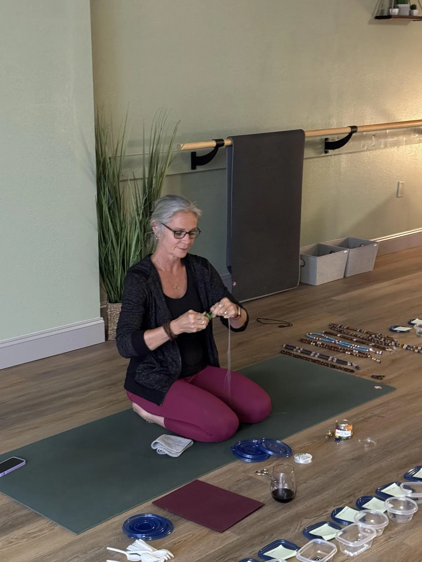 Jill threading mala beads during the mala workshop.