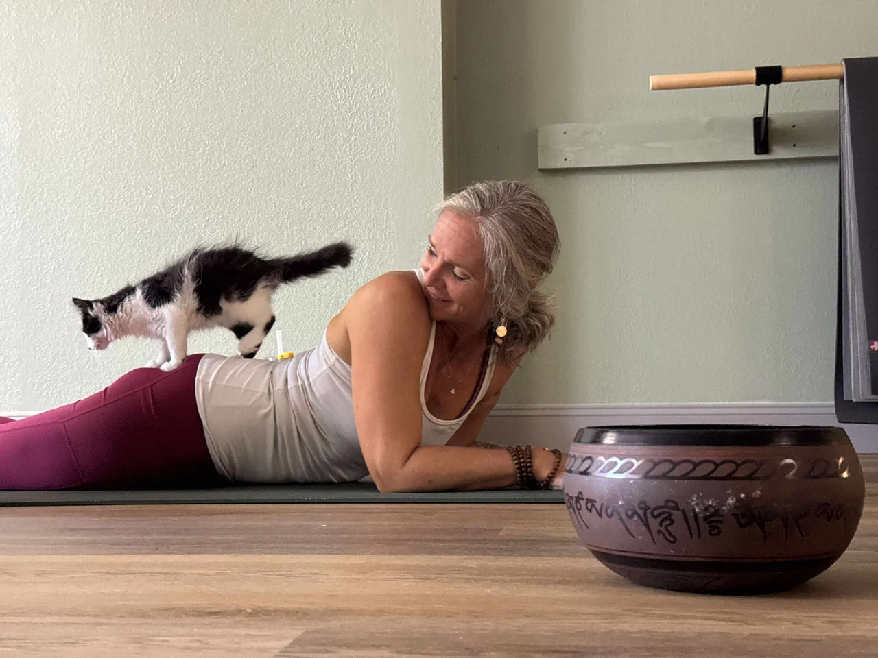 Jill on her mat with a visiting kitten during kitten yoga.
