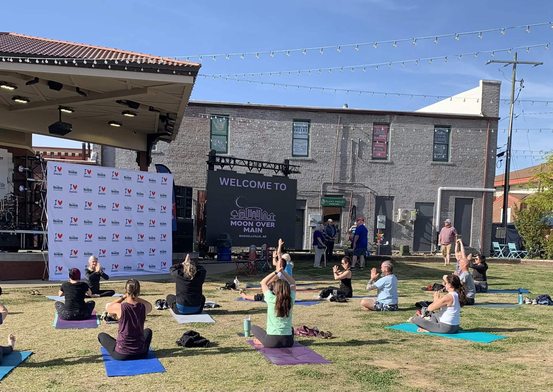 An outdoor practice on the lawn in downtown Russellville, the stage behind.