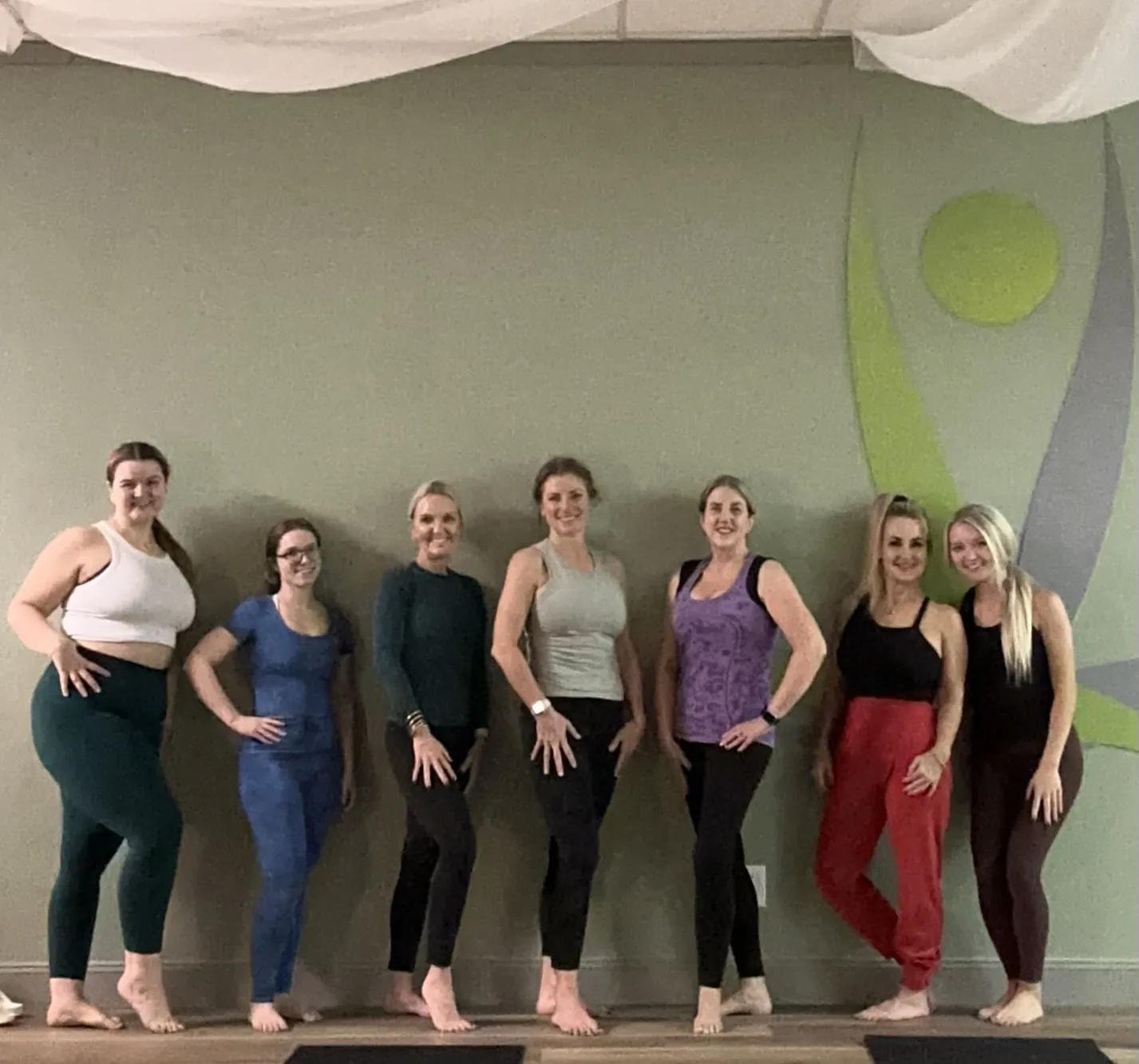 A group of students in front of the studio logo mural.