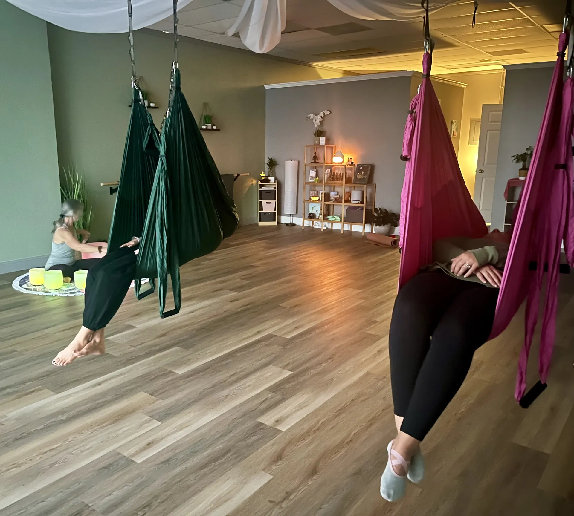 Students resting in the green and pink yoga trapeze hammocks.