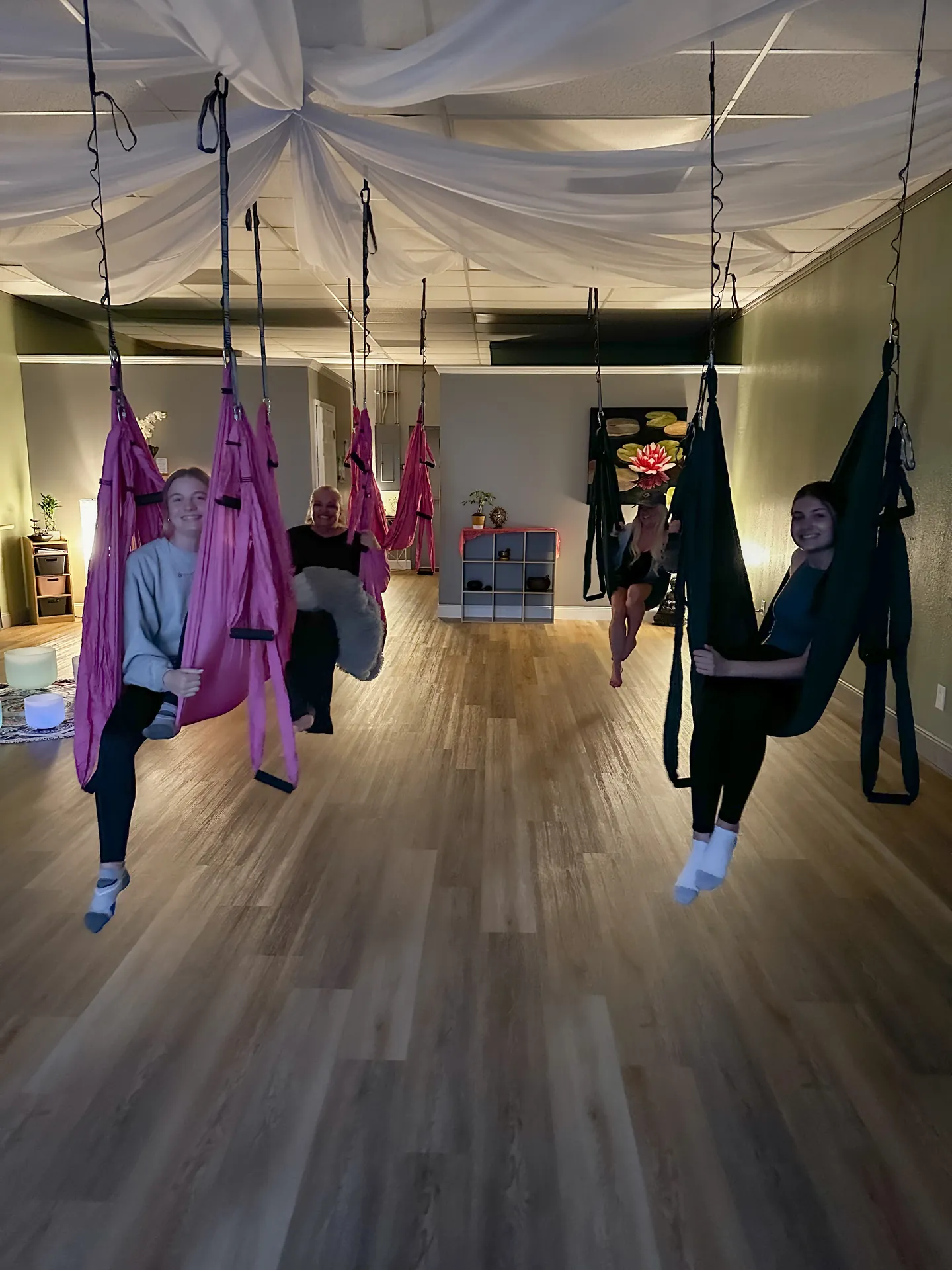 A yoga trapeze class beneath the draped ceiling.