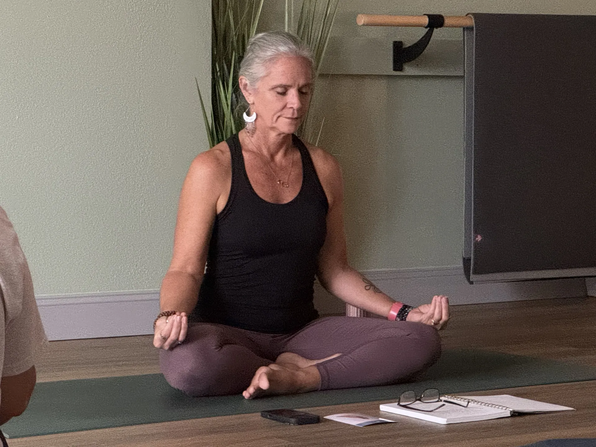 Jill seated in meditation at the front of the studio.