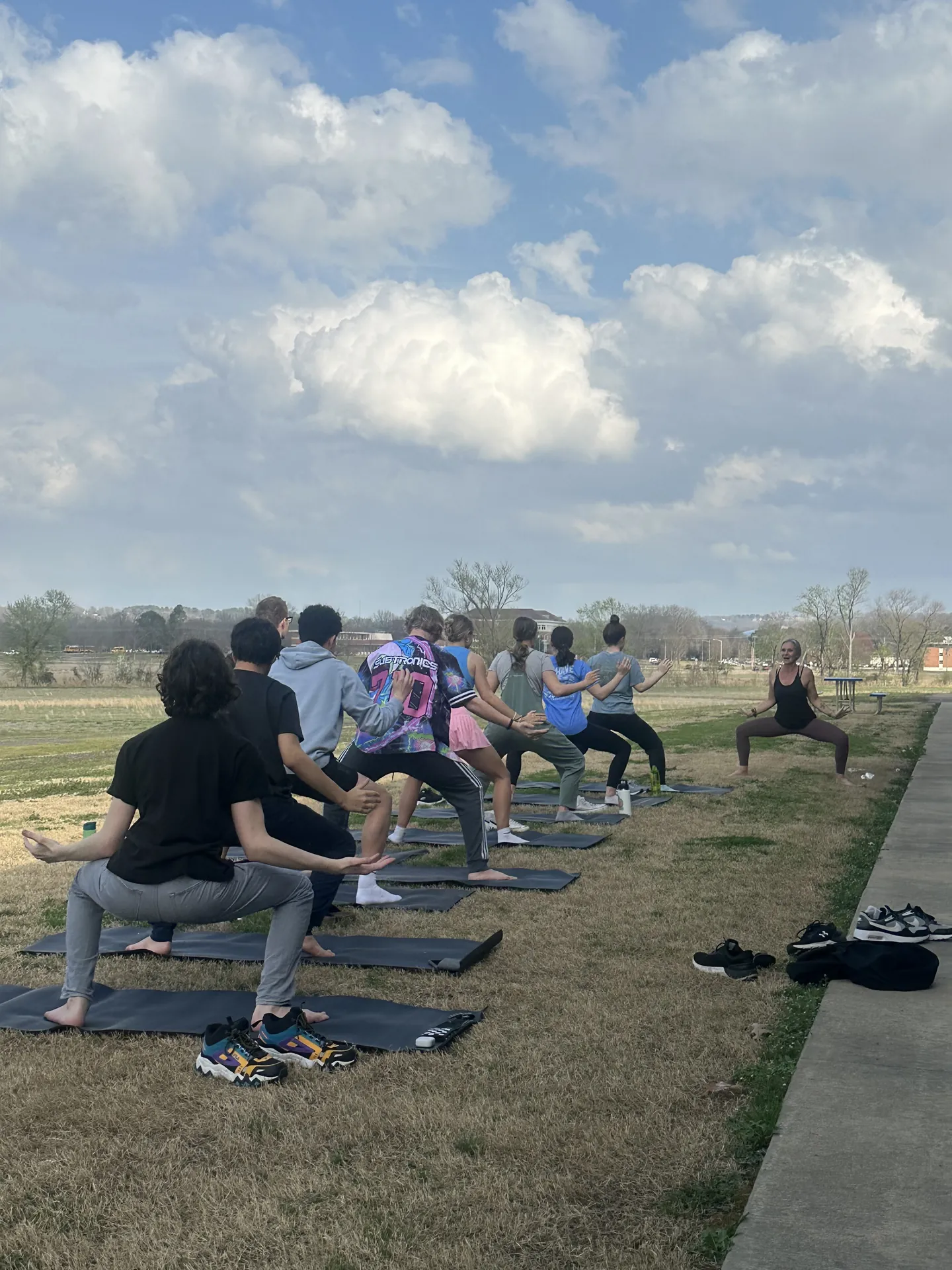 Lunges on the grass at an outdoor practice.