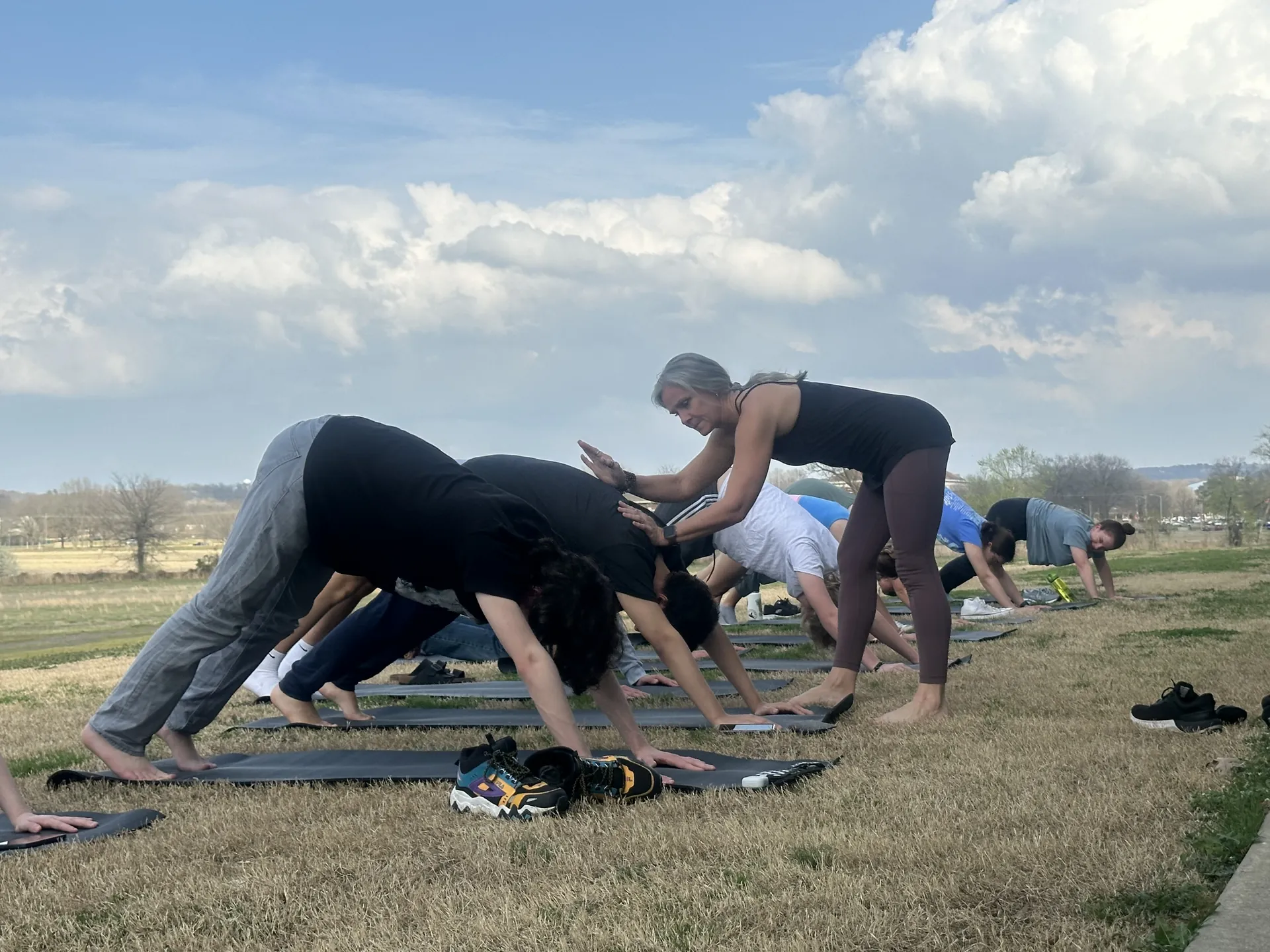 Downward dog on the grass under a big Arkansas sky.
