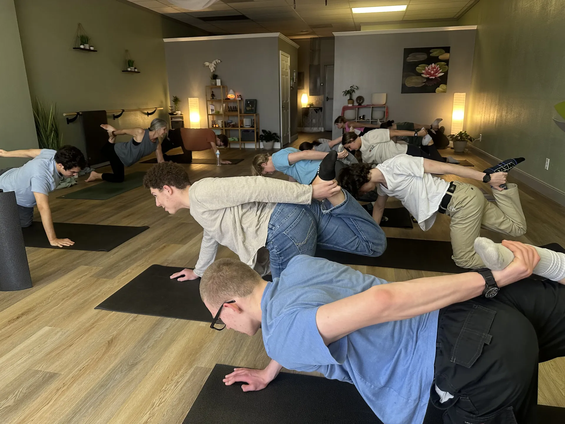 A side-plank variation in an evening class, warm lamplight in the room.