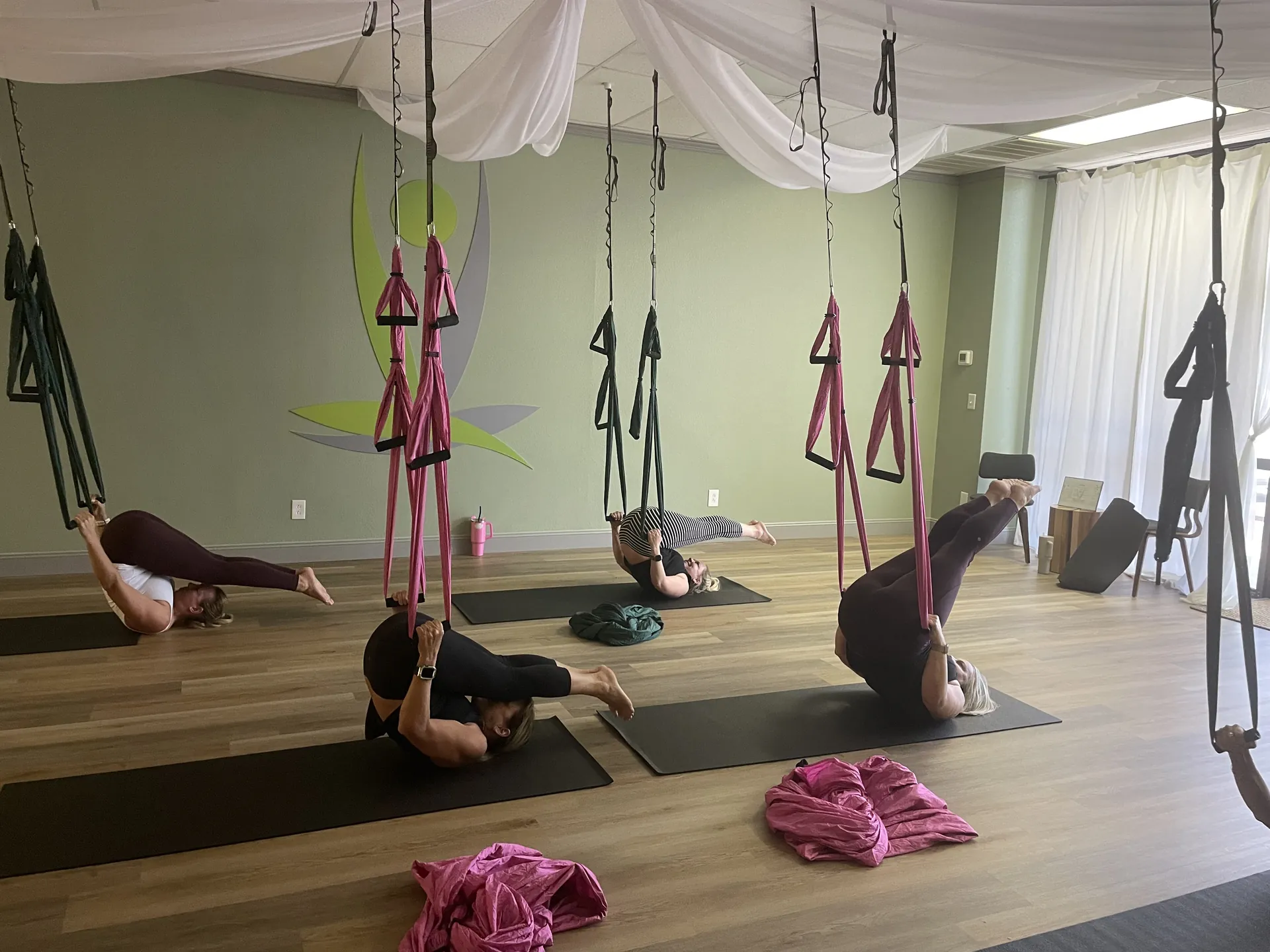 A trapeze class, students inverted in their hammocks.