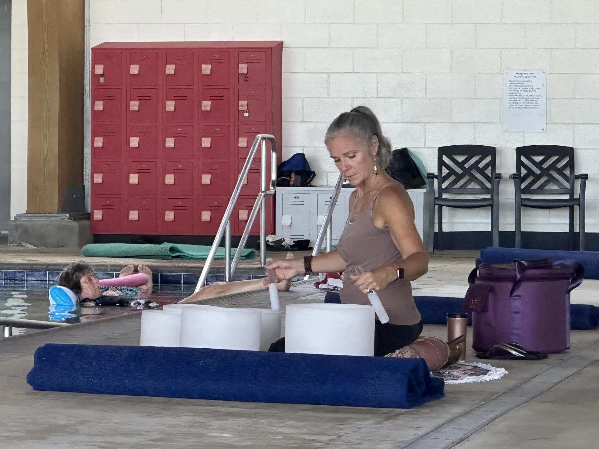 Jill setting up singing bowls at the pool for a water sound bath.